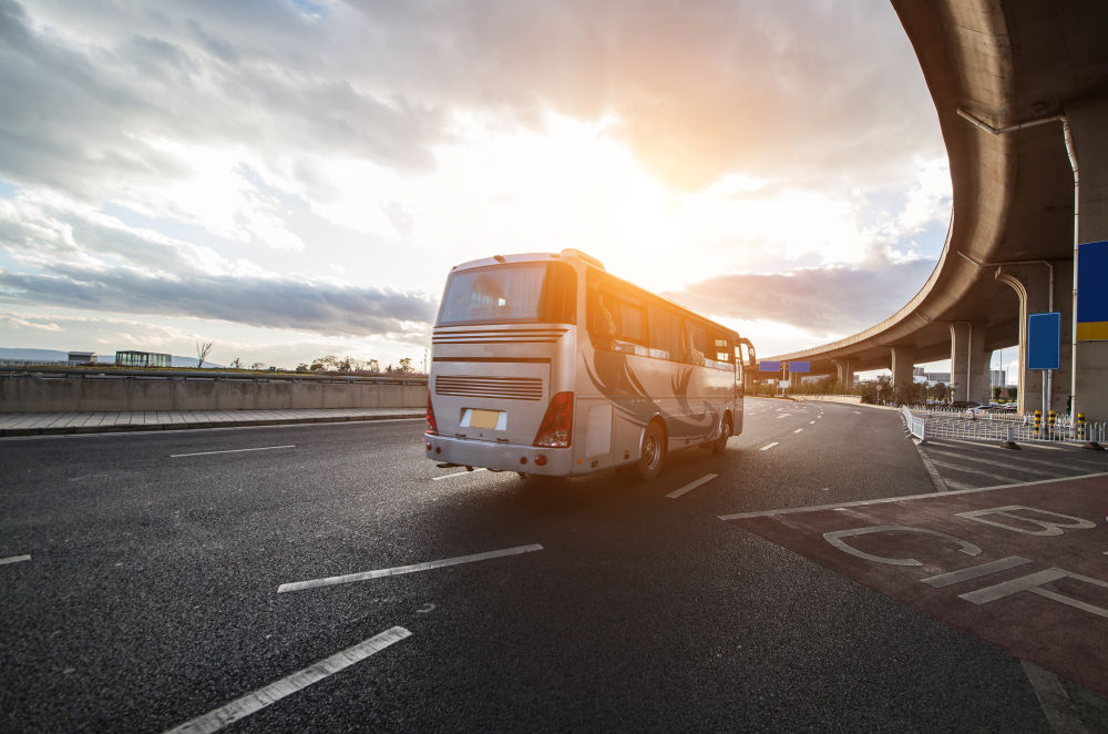 Ônibus rodoviário em rodovia ao pôr do sol – alternativa aos carros individuais nos transportes não poluentes." 