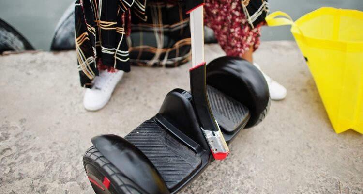African american woman using segway or hoverboard