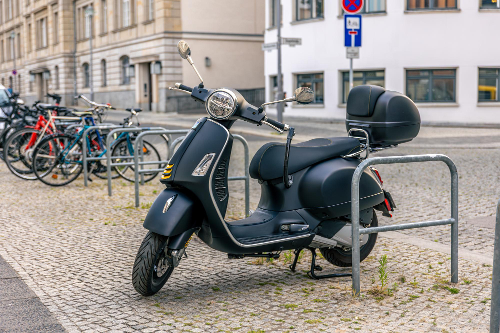 Moto elétrica preta estacionada em suporte urbano, destacando pontos importantes sobre como funciona a manutenção em moto elétrica.